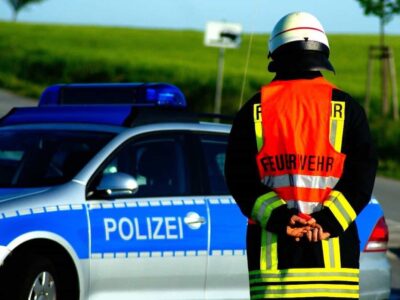 Feuerwehrmann vor einem Polizeiauto