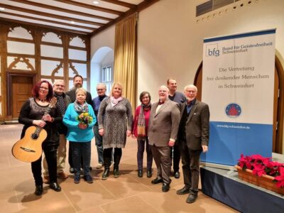 Die Jubilarin Ursula Schmid (4. von links) mit ihrem Ehemann, der Rednerin Birgit Ludwig (4. von rechts), der Gitarristin Judit Köcsky-Vogel (1. von links) sowie dem Vorstand und Ausschuss des bfg Schweinfurt