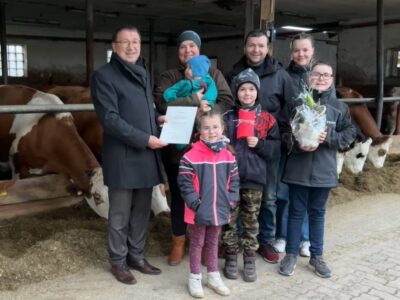 Friedel Heckenlauer übergibt die Urkunde des Bundespräsidenten an Familie Schmitt