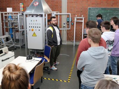 Maschinenbau-Student Awat Cheikhi (Mitte) beantwortet während der Besichtigung des Wasserstoff-Labors der THWS die Fragen der Schülerinnen und Schüler (Foto: THWS/Eva Kaupp)