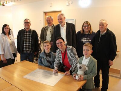 Der Symbolscheck wird ausgefüllt: Nadine Friedrich vom Stammheimer Theaterkreis mit ihren Söhnen Milo und Emil (vordere Reihe) sowie (v. l. n. r.) Tatiana Dürr (stv. Hausleiterin Lebenshilfe-Wohnpflegeheim Falkenring), Sascha Turtschany (Einrichtungsleiter Wohnheime Lebenshilfe Schweinfurt), Konrad Schneider (stv. Vorsitzender Lebenshilfe Schweinfurt), Jürgen Kriegbaum (geschäftsführender Vorstand ÜZ Mainfranken), Sabrina Schneeberger (Hausleiterin Lebenshilfe-Wohnpflegeheim Falkenring) sowie Rudolf Link (Hausfürsprecher Lebenshilfe-Wohnpflegeheim Falkenring). Foto: Reto Glemser