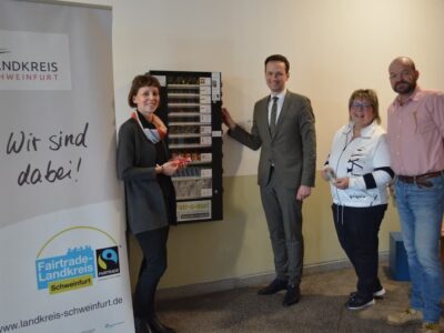 Im Bild von links: Regionalmanagerin Eva Krümpel, Landrat Florian Töpper, Petra Aumüller (Eine-Welt-Laden Gerolzhofen) und Kreisrat Udo Rumpel (Sprecher der Steuerungsgruppe Fairtrade) haben den Warenautomaten offiziell in Betrieb genommen. Foto: Melina Bosbach/LRASW