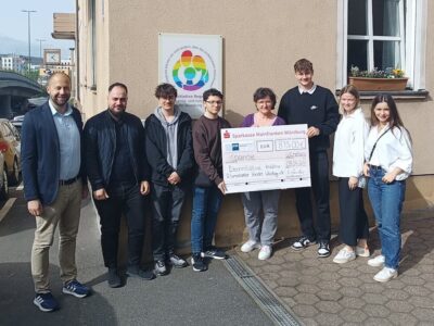Die IHK-Auszubildenden überreichen den Spendenscheck im Beisein von IHK-Hauptgeschäftsführer Dr. Sascha Genders (links) an die Würzburger Elterninitiative Regenbogen. Foto: Elterninitiative Regenbogen