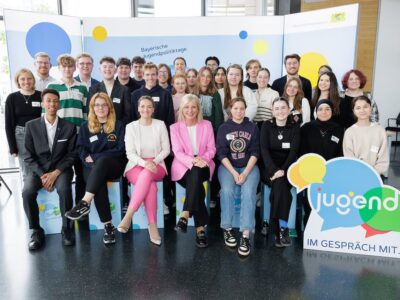 Das Foto zeigt Jugendministerin Ulrike Scharf zusammen mit Gesundheitsministerin Judith Gerlach (erste Reihe, dritte von links) und Teilnehmerinnen und Teilnehmern der Veranstaltung „Jugend im Gespräch mit dem StMGP!“. Fotoquelle: StMAS / Nötel