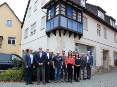 (Foto: Reto Glemser): Feiern zusammen die Eröffnung der neuen Regionalstelle von „Mensch inklusive“ in Münnerstadt (v. l.): Michael Kastl (Erster Bürgermeister Münnerstadt), Norbert Hart (Vorsitzender Lebenshilfe Schweinfurt), Martin Groove (Geschäftsführer Lebenshilfe Schweinfurt), Jan Müller, Ingo Niebling und Stefan Kohlhepp (Inklusionsbegleiter „Mensch inklusive“), Eva Lieb (Leiterin „Mensch inklusive), Wolfgang Wirth (Berater berufliche Rehabilitation und Teilhabe Agentur für Arbeit Schweinfurt), Marion Kraus (Fachdienst „Mensch inklusive“), Emil Müller (stellvertretender Landrat Bad Kissingen) und Bruno Altrichter (stellvertretender Landrat Rhön-Grabfeld).