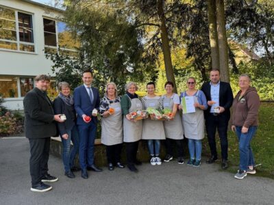 Regional einkaufen und frisch zubereiten lautet das Motto im Karl-Beck-Haus – über die erfolgreiche Teilnahme am Bio-Regio-Coaching freuen sich, von links: Oliver Pfister (Leiter Karl-Beck-Haus), Coach Beate Laumeyer (AELF), Landrat Florian Töpper sowie vom Küchenteam Hanolore Walter, Stefanie Stöhr, Fang Ji, Birgitt Wahler, Beate Karrlein nebst Schonungens Bürgermeister Stefan Rottmann und Andrea Zimmermann vom Biohof Zimmermann (Abersfeld). Foto: Andreas Lösch/Landratsamt Schweinfurt