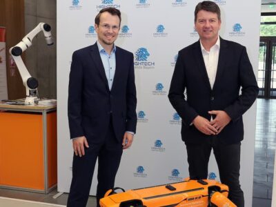 Gruppenbild mit Roboterhund Spot: THWS-Präsident Prof. Dr. Jean Meyer (links) und Staatssekretär Sandro Kirchner beim Besuch des CERI, Center für Robotik in Schweinfurt (Foto: THWS/Eva Kaupp)