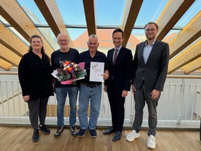 Jerry White (Mitte) wurde für seinen langjährigen Dienst als Schulweghelfer mit der Ehrenurkunde der Verkehrswacht Schweinfurt geehrt, es gratulierten (von rechts) Christoph Saubert (stellv. Vorsitzender der Verkehrswacht Schweinfurt), Landrat Florian Töpper sowie (von links) Tina Sauer (Geschäftsführerin der Verkehrswacht Schweinfurt) und Adi Schön (Vorsitzender der Verkehrswacht Schweinfurt). Foto: Andreas Lösch/Landratsamt Schweinfurt