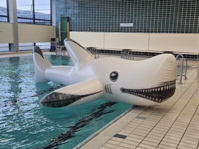 Nicht nur auf hoher See fühlen sich Haie wohl – auch im Rahmen der Spielstunde tummeln sich aufblasbare Haie im Becken, ein Piratenfloß und andere Spielgeräte. (Foto St. Rottmann)