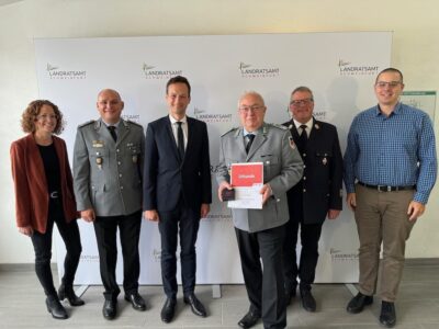 Oberstleutnant Oliver Jung (mit Urkunde) wurde als Leiter des Kreisverbindungskommandos des Landkreises Schweinfurt der Bundeswehr verabschiedet. Im Bild, von links: Sonja Weidinger (Leiterin Abteilung Öffentliche Sicherheit und Ordnung), Oberstleutnant d. R. Thomas Strobel (Leiter des Kreisverbindungskommandos der Stadt Schweinfurt), Landrat Florian Töpper sowie (von rechts) Arbeitsbereichsleiter Katastrophenschutz und Feuerwehrwesen Florian Zippel und Kreisbrandrat Holger Strunk. Foto: Andreas Lösch/Landratsamt Schweinfurt